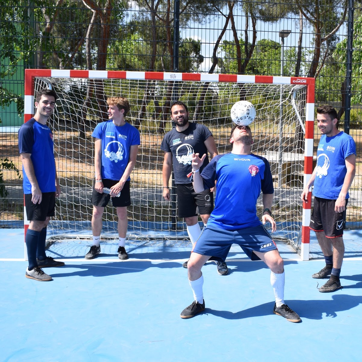 Photo of a 5-man football team in the National Erasmus Games, one of them balancing the ball in his head.